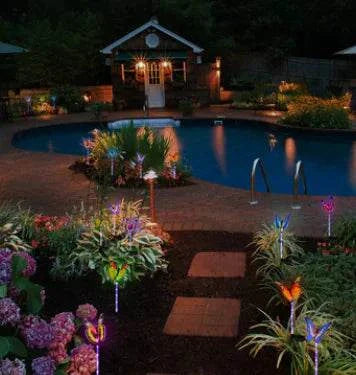 7 color changing LED garden lights illuminating in purple, green, and orange hues at night
