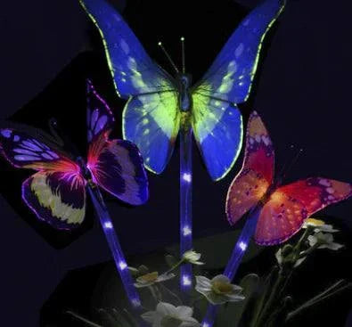 Solar Magic Butterfly Lights with 7 color changing LED fiber optic butterflies glowing in garden at night