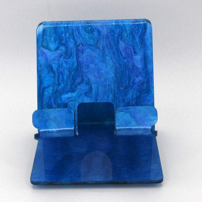 Global Phone Stand in vibrant blue marble acrylic, fits most smartphones, durable and easy to clean with rubber feet for grip.